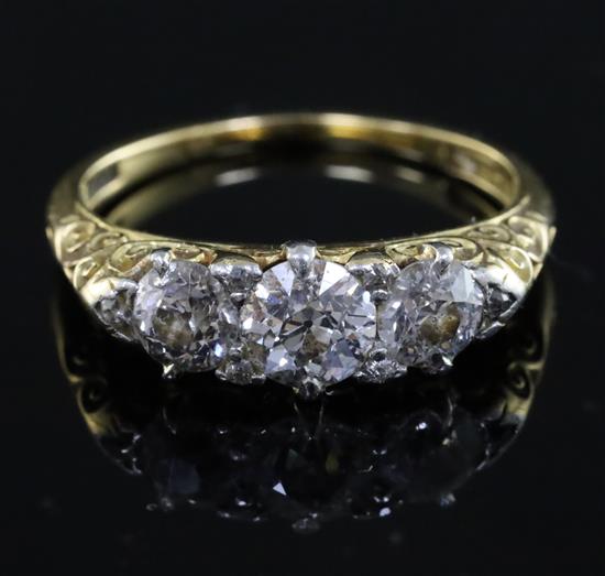 An Edwardian 18ct gold and graduated three stone diamond ring, size O.